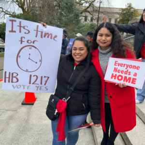 Advocates hold signs in support of HB 1217, a bill in Washington state designed to bring stability and predictability to a rental market that's escalating at an unsustainable rate. This is at Housing and Homelessness Advocacy Day 2025.